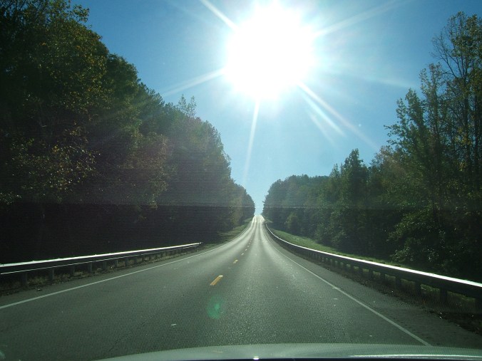 long straight stretch of road with bright sun in view