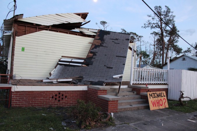 destroyed house with a sign that says, "Michael Who?"